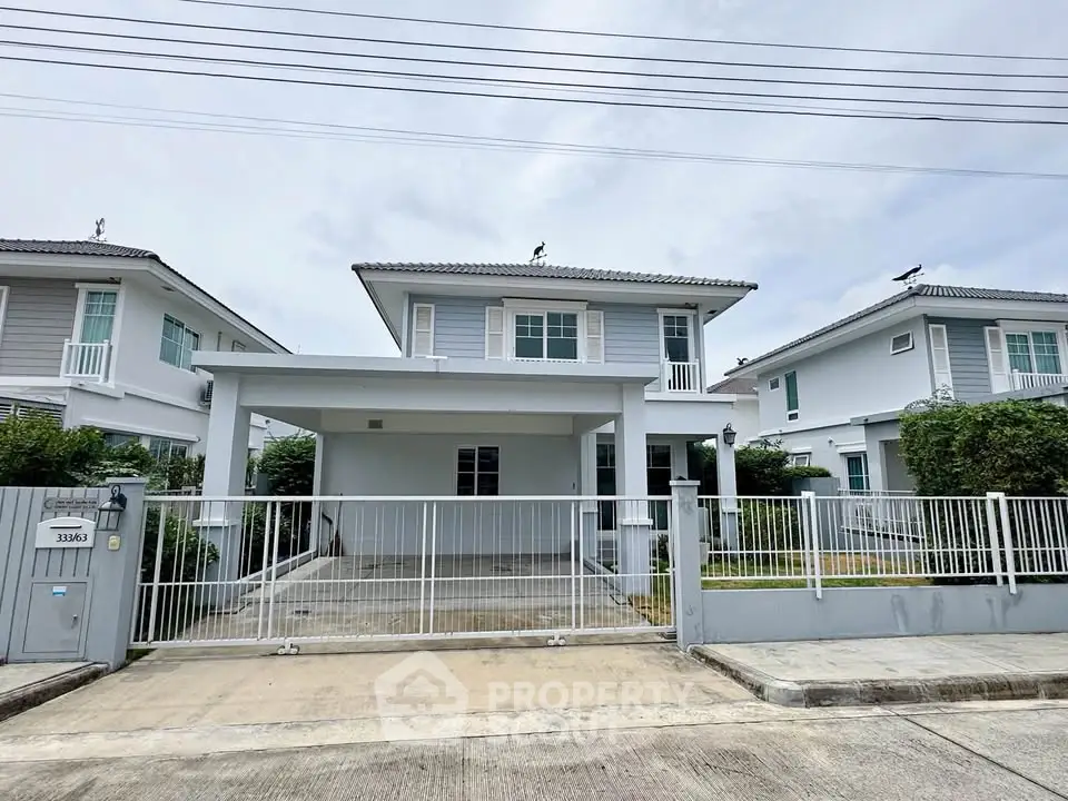 Modern two-story house with spacious driveway and gated entrance in a suburban neighborhood.