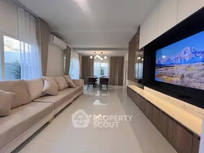 Spacious modern living room with large TV and elegant dining area