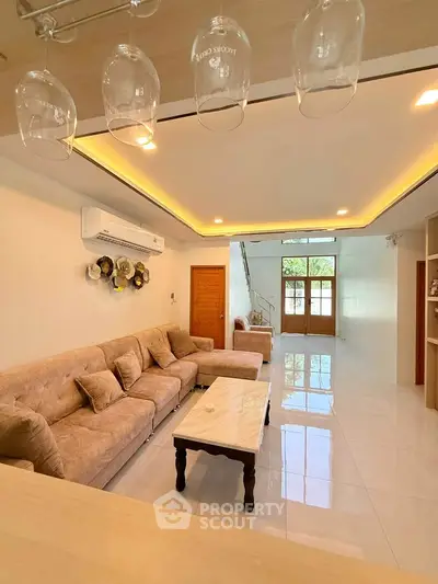 Spacious living room with elegant decor and modern lighting, featuring a comfortable sofa and stylish coffee table.