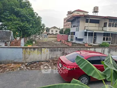 Spacious property with potential for development, featuring a large open area and surrounding buildings.