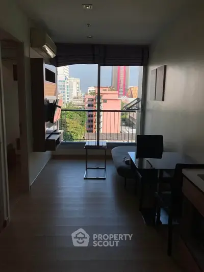 Modern living room with city view, featuring sleek furniture and large windows for natural light.