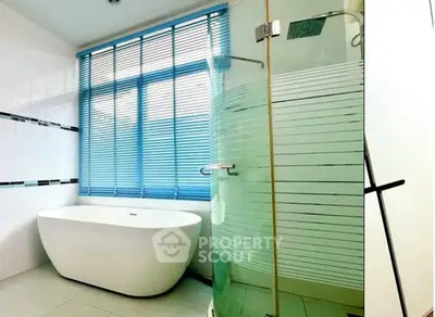 Modern bathroom with freestanding bathtub and glass shower enclosure