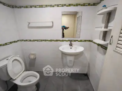 Modern bathroom with sleek fixtures and minimalist design, featuring a wall-mounted sink and toilet.