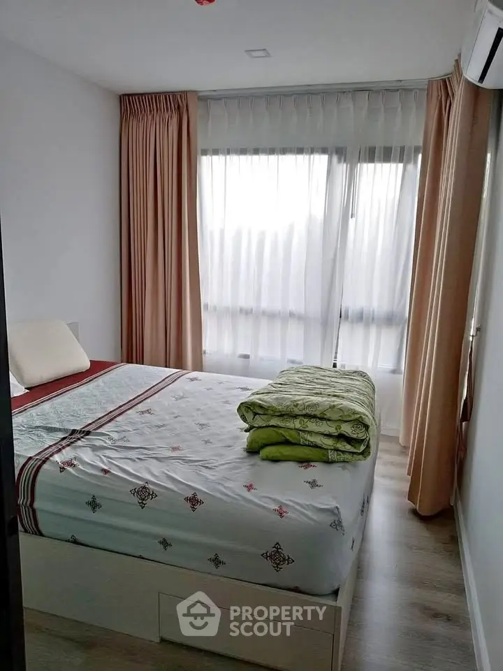 Cozy bedroom with large window and elegant curtains, featuring a comfortable bed and modern decor.
