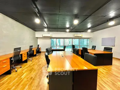 Spacious modern office space with wooden flooring and city view, ideal for productivity and collaboration.