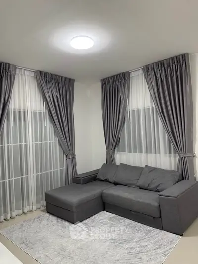 Modern living room with gray sofa and elegant curtains, perfect for cozy relaxation.