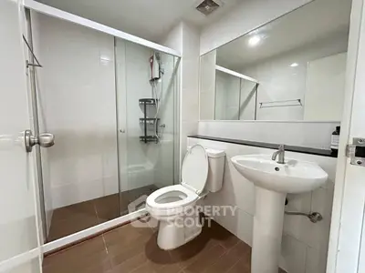 Modern bathroom with glass shower and sleek fixtures in a contemporary apartment.