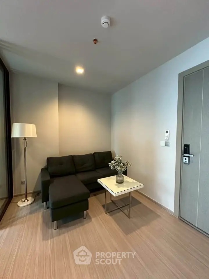 Modern living room with sleek black sofa and stylish decor in a contemporary apartment.