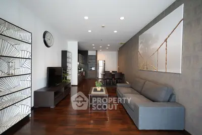 Modern living room with open kitchen, stylish decor, and hardwood floors in a contemporary apartment.