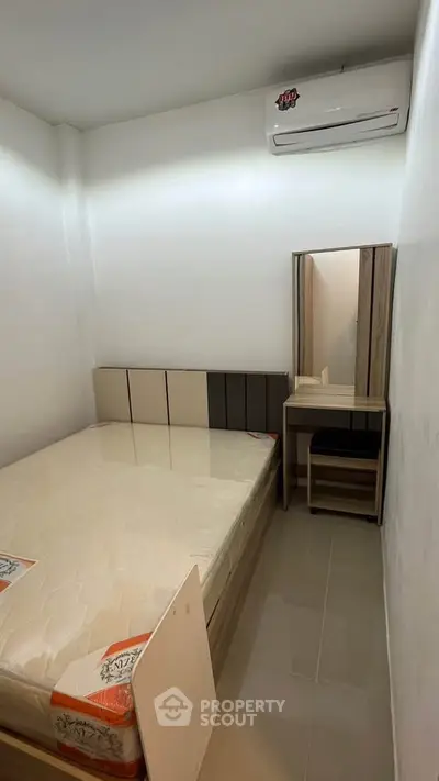 Cozy bedroom with minimalist design and air conditioning unit.