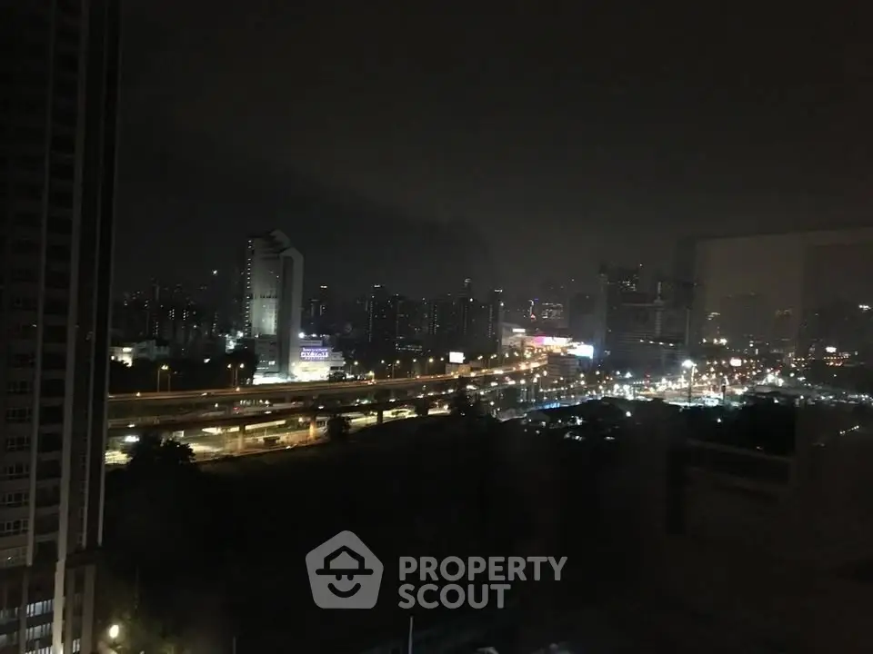 Stunning cityscape night view from high-rise building window, showcasing vibrant urban lights and skyline.