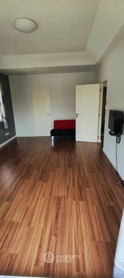 Spacious room with wooden flooring and modern decor, perfect for versatile living space.