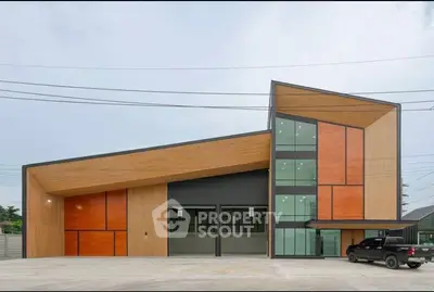 Modern commercial building with unique architecture and spacious parking area.