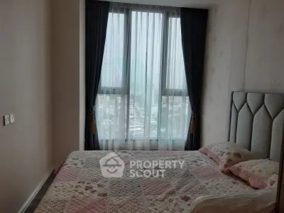 Cozy bedroom with large window offering city view, featuring elegant curtains and a stylish bed setup.