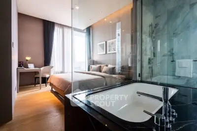Luxurious bedroom with ensuite bathroom featuring a modern bathtub and elegant decor.