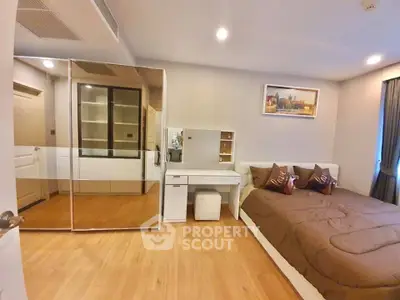 Modern bedroom with mirrored wardrobe and cozy decor in a stylish apartment.