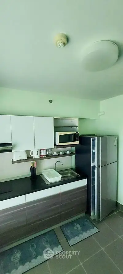 Modern kitchen with sleek cabinets and stainless steel appliances in a stylish apartment.