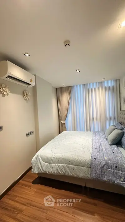 Cozy bedroom with modern decor and natural light in a stylish apartment.