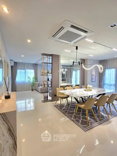 Luxurious open-plan living and dining area with modern decor and elegant lighting.