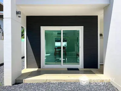 Modern exterior with sliding glass doors and sleek black paneling