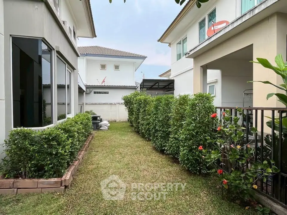Charming suburban backyard with lush greenery and modern house exteriors, perfect for family living.