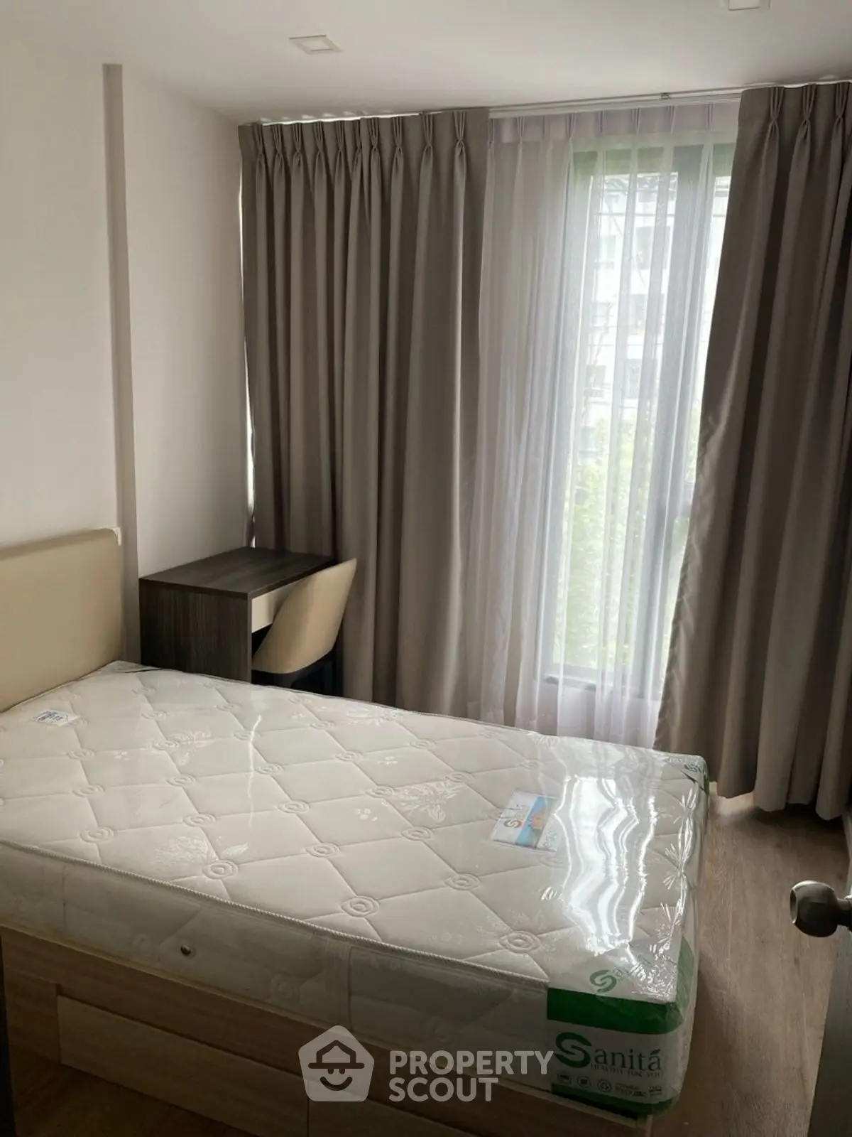 Cozy bedroom with natural light and modern furnishings, ideal for urban living.
