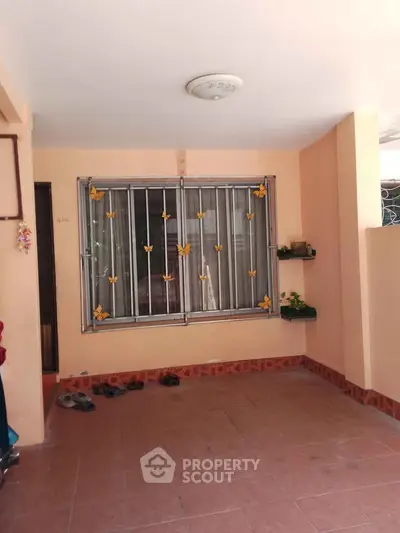 Charming home entrance with decorative window bars and tiled flooring, perfect for a cozy welcome.
