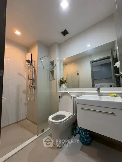 Modern bathroom with sleek design, featuring a glass shower and contemporary fixtures.