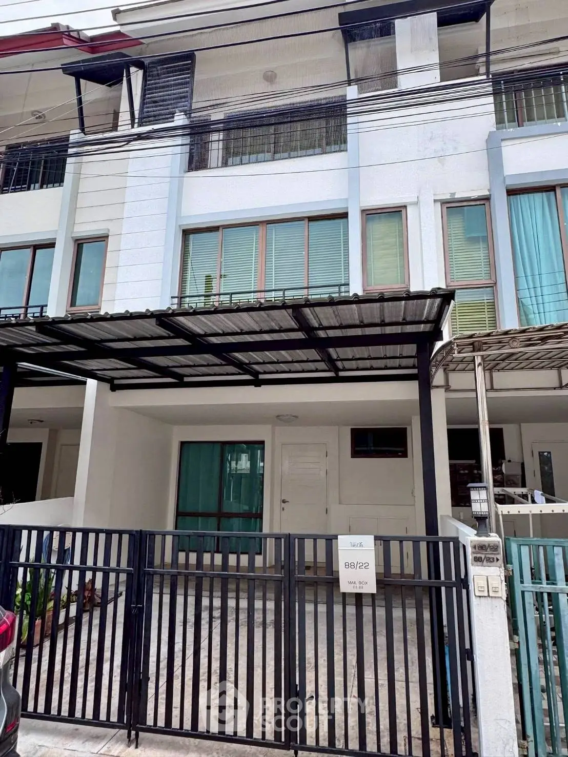 Modern townhouse exterior with gated parking and large windows