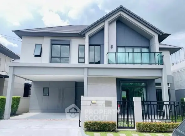 Modern two-story house with sleek design and spacious driveway in a serene neighborhood.