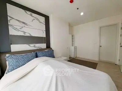 Modern bedroom with stylish decor and cozy bedding in a contemporary apartment.