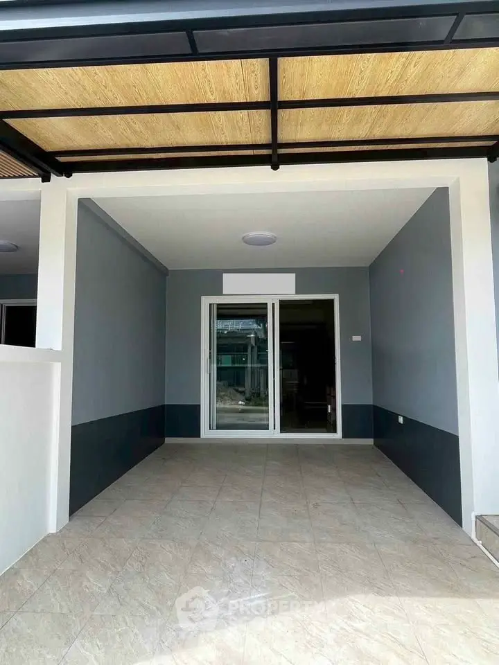 Modern covered parking space with tiled flooring and sliding glass doors.