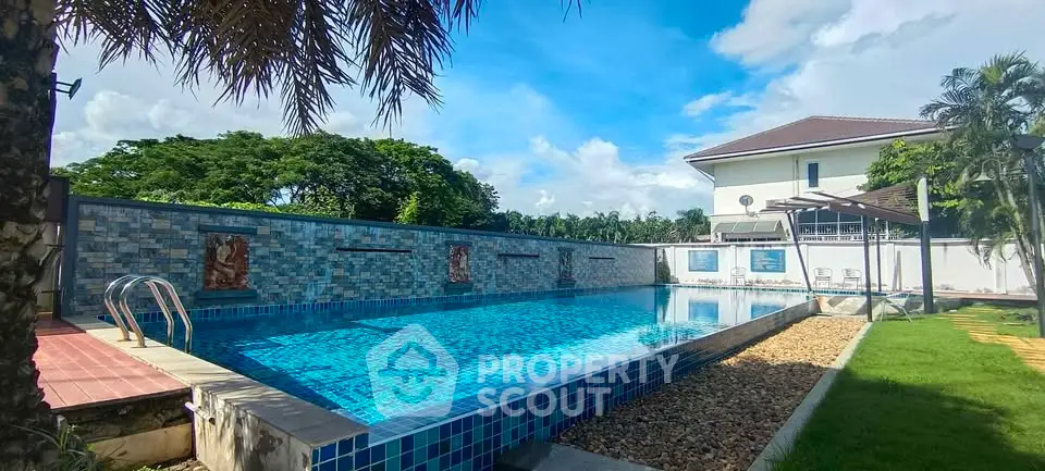 Luxurious outdoor pool with serene garden view in a modern residential property.