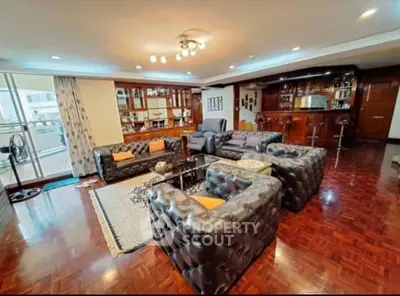Luxurious living room with elegant leather sofas and open kitchen layout, perfect for entertaining.