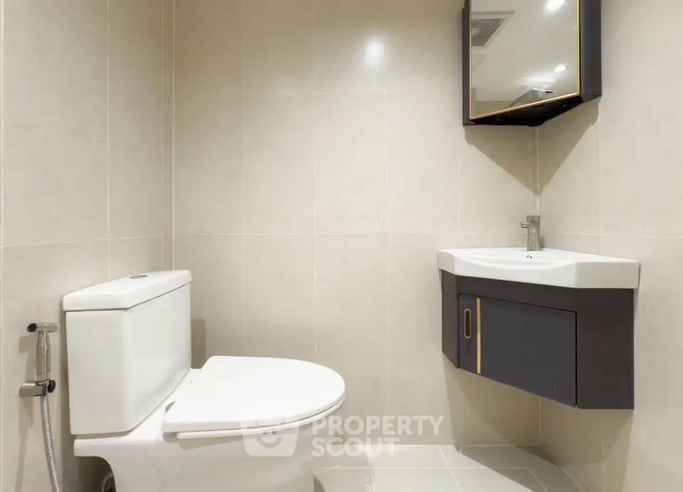 Modern bathroom with sleek fixtures and wall-mounted sink in a minimalist design.