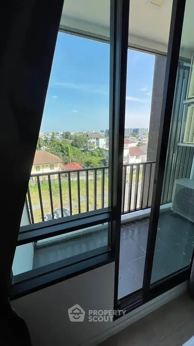 Charming balcony view with cityscape and lush greenery, perfect for relaxation.