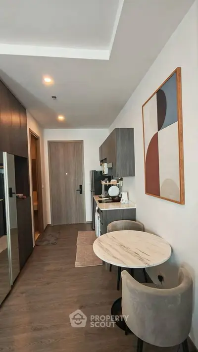 Modern apartment interior with stylish kitchen and dining area, featuring contemporary decor and sleek finishes.