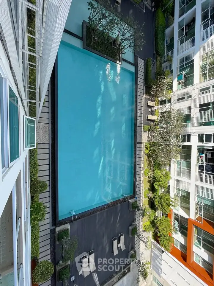 Stunning aerial view of modern apartment complex with inviting swimming pool and lush greenery.
