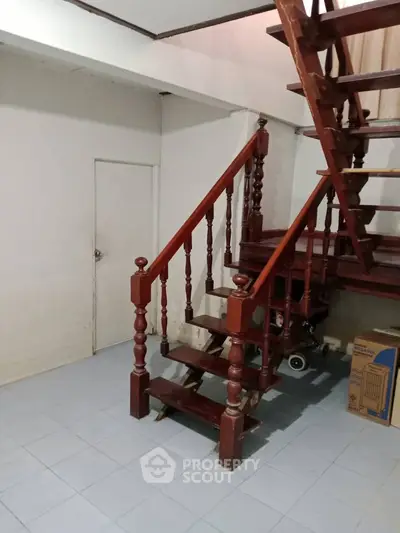 Charming wooden staircase in cozy interior space with tiled flooring, perfect for a warm home ambiance.