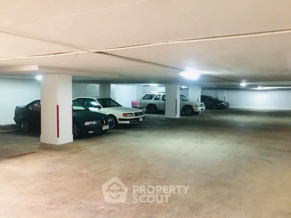 Spacious underground parking area with multiple cars parked, well-lit and secure.