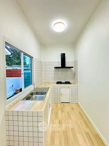 Modern kitchen with sleek gas stove and wooden flooring, perfect for culinary enthusiasts.