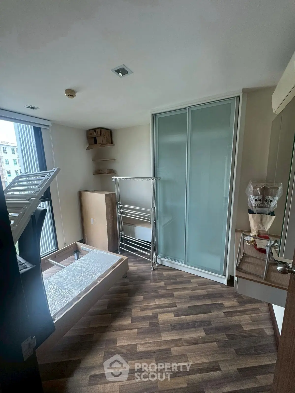 Spacious bedroom with modern sliding closet doors and large window view.