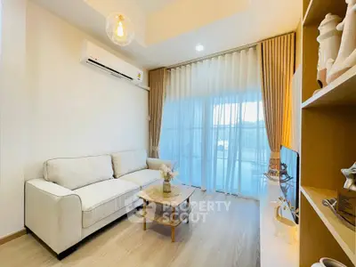 Modern living room with cozy sofa and elegant decor, featuring large windows and natural light.