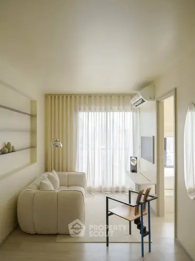 Modern living room with cozy sofa, stylish chair, and natural light from large window.