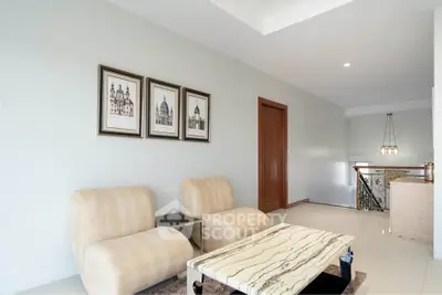 Elegant living room with modern chairs and marble table, perfect for relaxation.