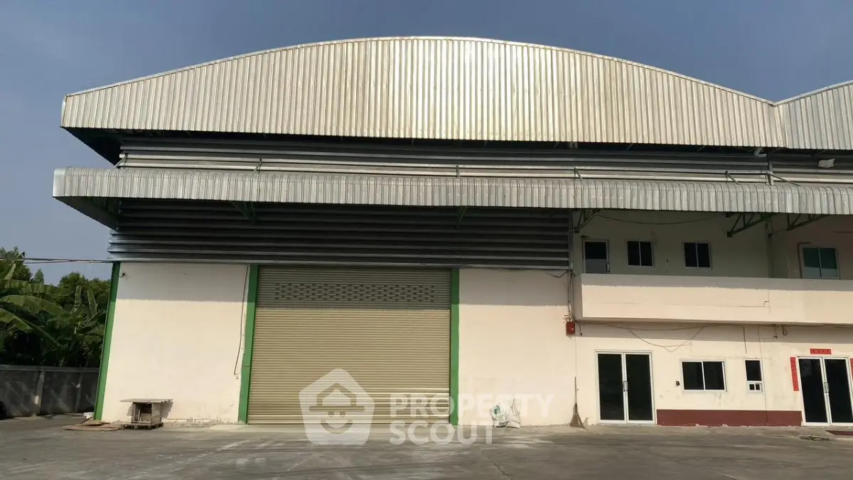 Spacious industrial warehouse exterior with large roller door and ample outdoor space.