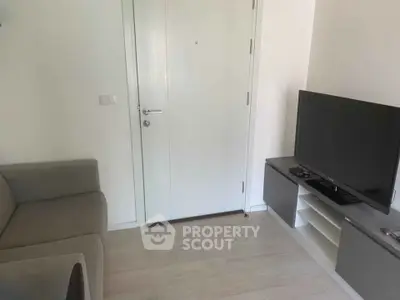 Cozy living room with modern TV setup and comfortable sofa, perfect for relaxation.