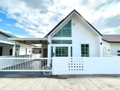 Charming modern house with white facade and large windows, perfect for family living.