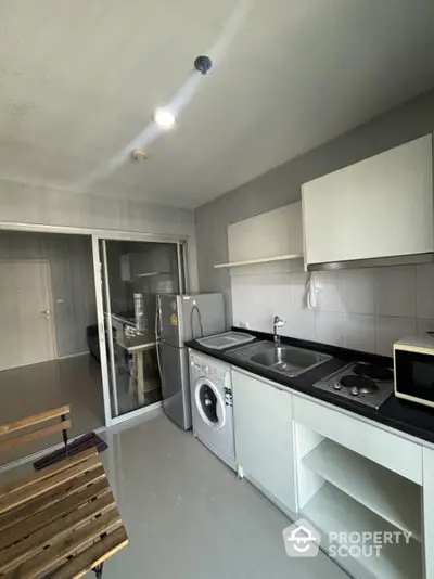 Modern kitchen with washing machine and sleek cabinetry in a stylish apartment