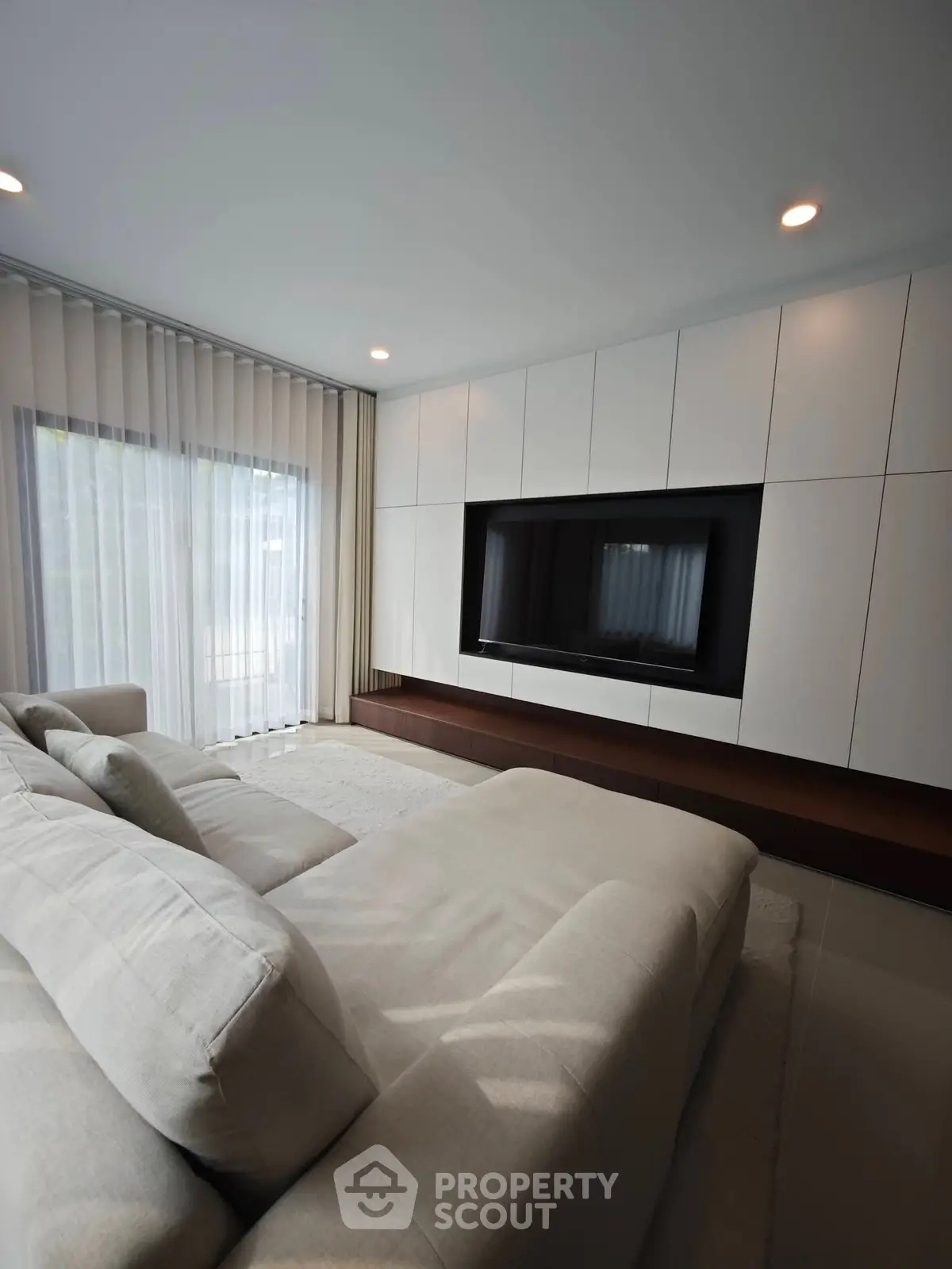 Luxurious modern living room with sleek built-in entertainment center and plush sofa.